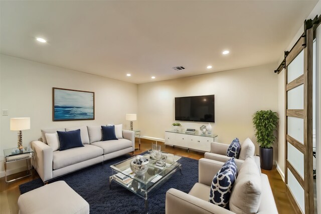 living room with hardwood / wood-style flooring and a barn door