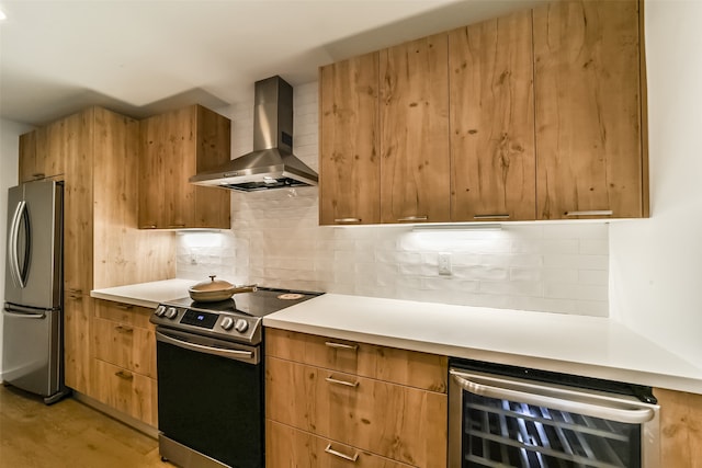 kitchen with wall chimney exhaust hood, tasteful backsplash, appliances with stainless steel finishes, and wine cooler