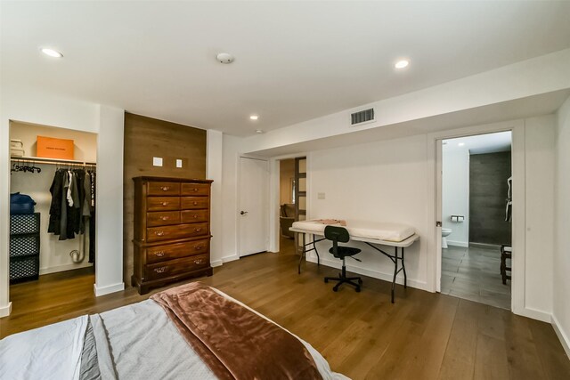 bedroom featuring dark hardwood / wood-style floors, a closet, and ensuite bathroom