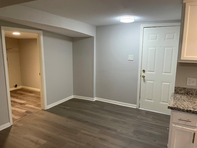 unfurnished dining area featuring dark wood-type flooring