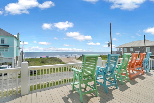 wooden terrace featuring a water view and a view of the beach