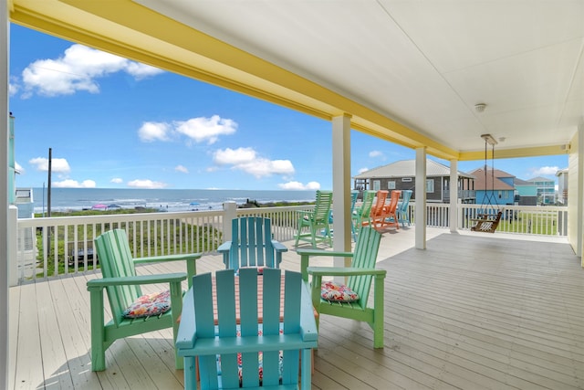 wooden deck with a water view and a view of the beach