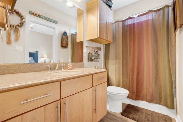 bathroom featuring curtained shower, hardwood / wood-style floors, vanity, and toilet