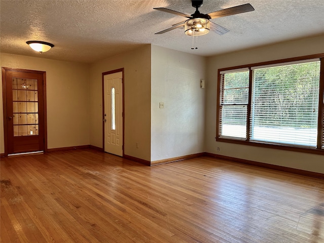 foyer entrance featuring a textured ceiling, light wood-type flooring, and ceiling fan