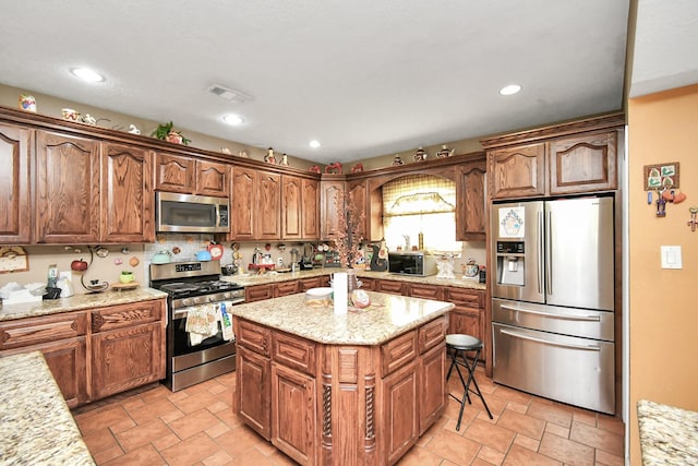 10510 Crosby Lynchburg Rd, Crosby, TX 77532 - kitchen with appliances with stainless steel finishes, a kitchen island, light stone finish flooring, light stone counters, and recessed lighting