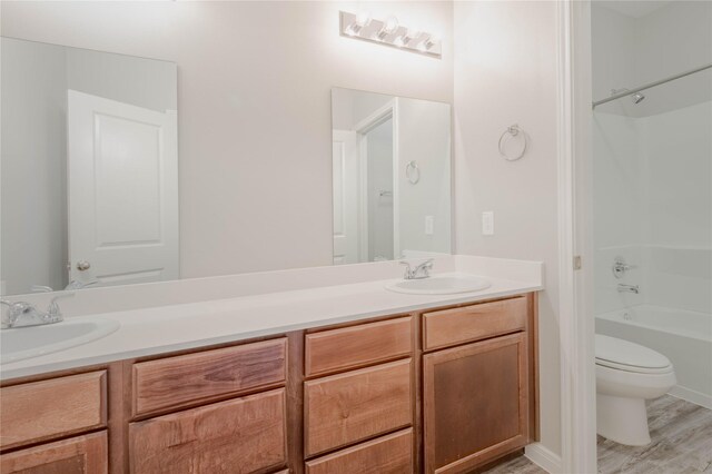 full bathroom featuring shower / tub combination, hardwood / wood-style floors, toilet, and vanity