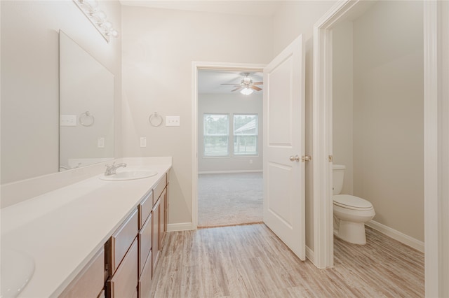 bathroom with ceiling fan, toilet, hardwood / wood-style flooring, and vanity