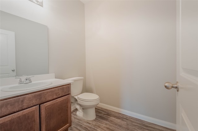 bathroom featuring vanity, toilet, and hardwood / wood-style floors