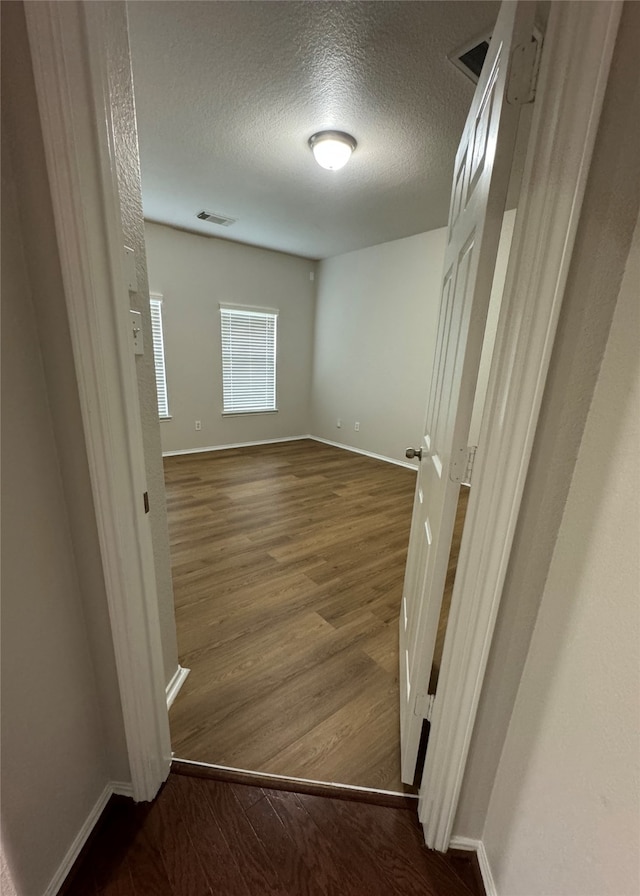 interior space featuring hardwood / wood-style flooring and a textured ceiling