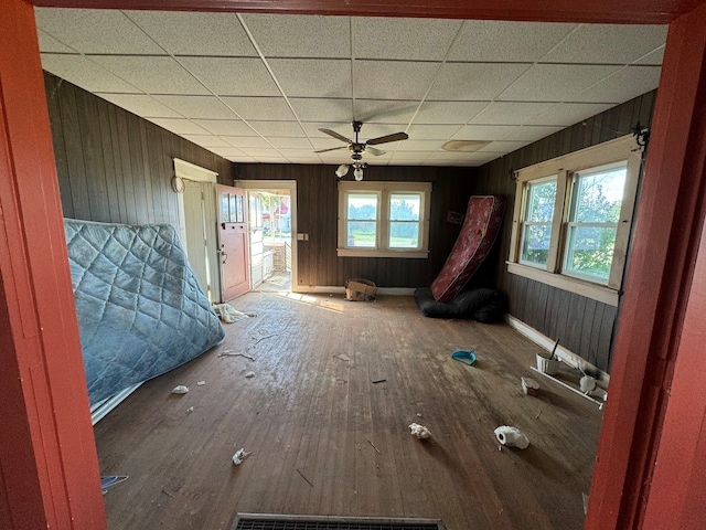 misc room with ceiling fan, hardwood / wood-style flooring, plenty of natural light, and wooden walls