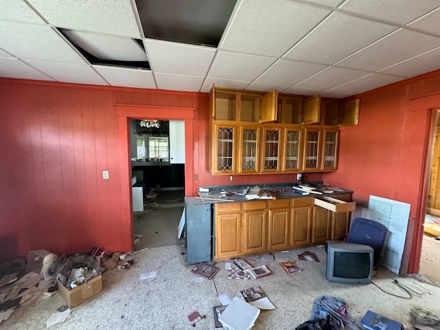 kitchen featuring a paneled ceiling and wood walls