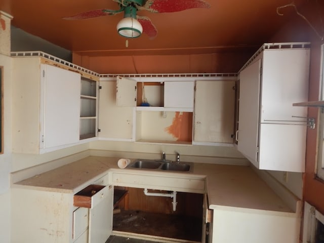 kitchen featuring white cabinets, ceiling fan, and sink