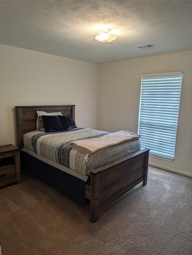 carpeted bedroom featuring a textured ceiling