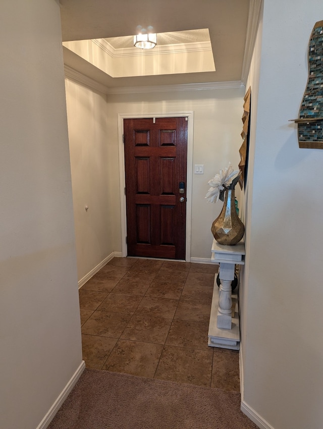 carpeted entrance foyer featuring a raised ceiling and ornamental molding