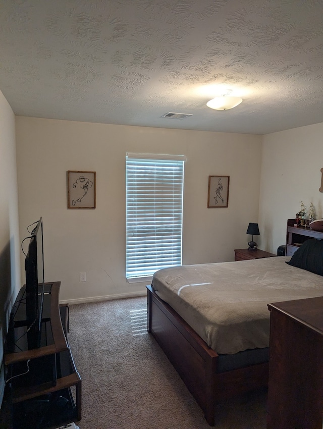 bedroom with carpet and a textured ceiling