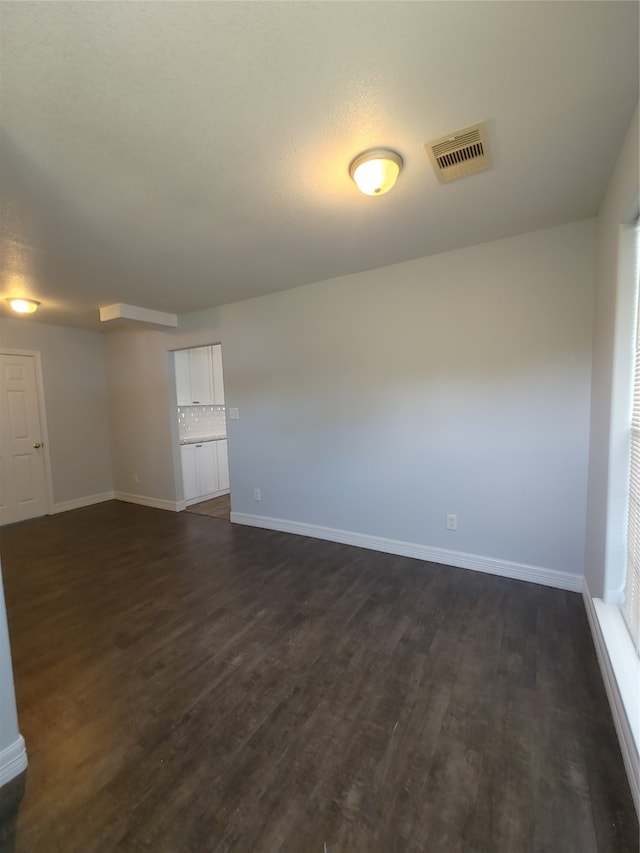 empty room with dark hardwood / wood-style flooring