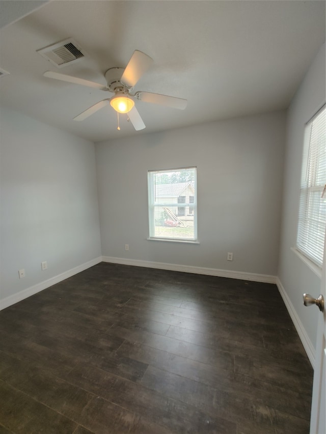 empty room featuring dark hardwood / wood-style flooring, plenty of natural light, and ceiling fan