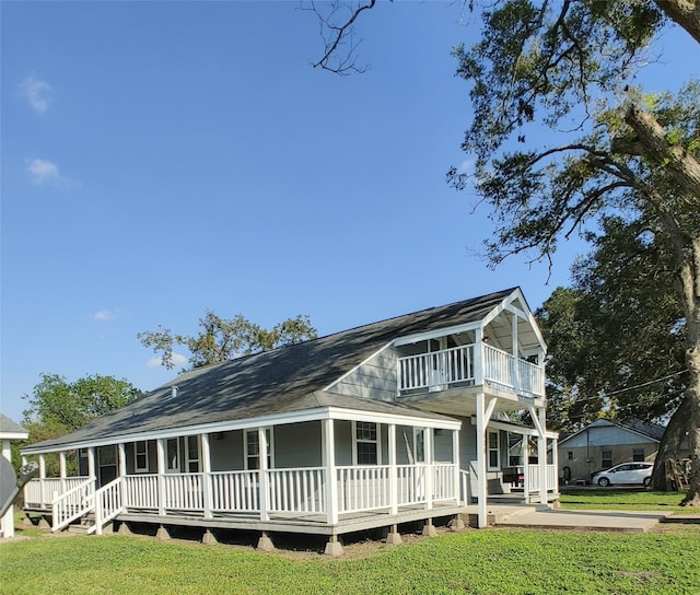 view of front of property with a balcony, a front lawn, and covered porch