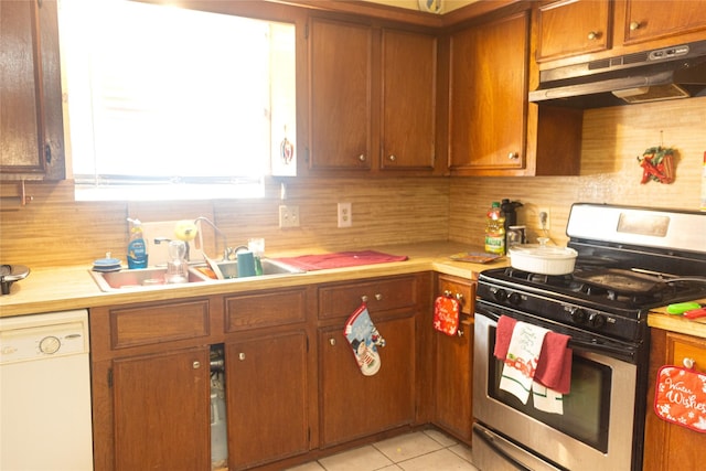 kitchen with dishwasher, stainless steel gas stove, sink, backsplash, and light tile patterned flooring