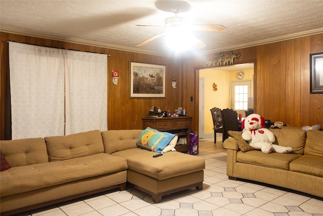 living room with wood walls, a textured ceiling, and ornamental molding