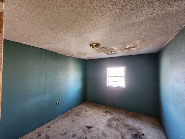 carpeted spare room with a textured ceiling