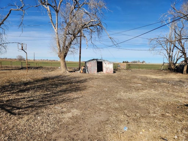 view of yard featuring a rural view and a shed