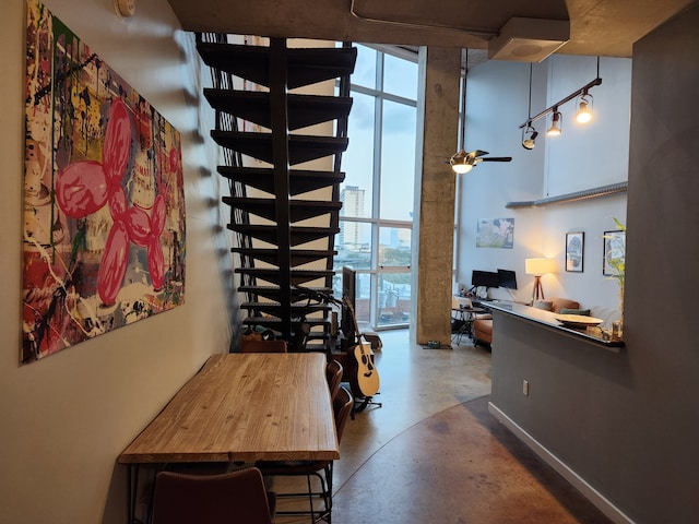 dining area with floor to ceiling windows, concrete floors, and ceiling fan