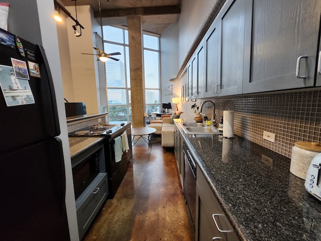 kitchen featuring dark stone counters, backsplash, black appliances, sink, and ceiling fan