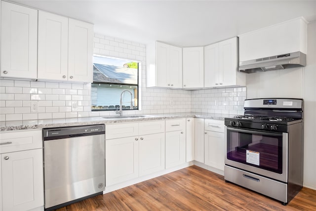 kitchen featuring hardwood / wood-style floors, stainless steel appliances, white cabinetry, and sink