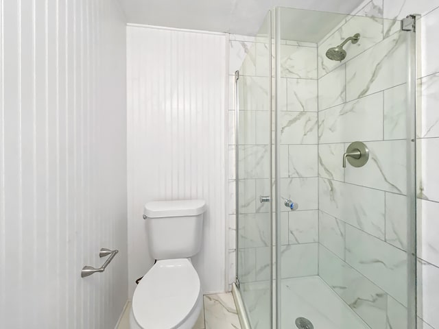 bathroom with a shower with shower door and toilet