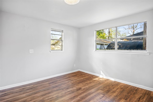 unfurnished room with a healthy amount of sunlight and hardwood / wood-style floors