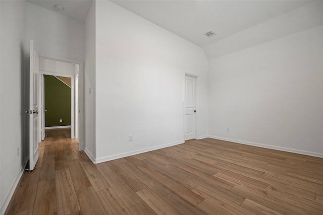 spare room with high vaulted ceiling and hardwood / wood-style flooring