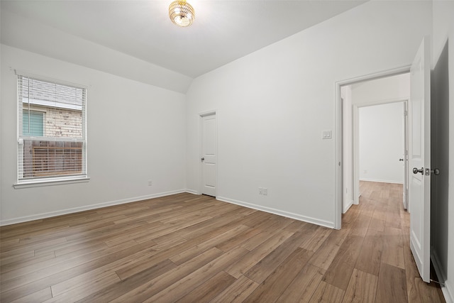 empty room featuring lofted ceiling and light hardwood / wood-style floors