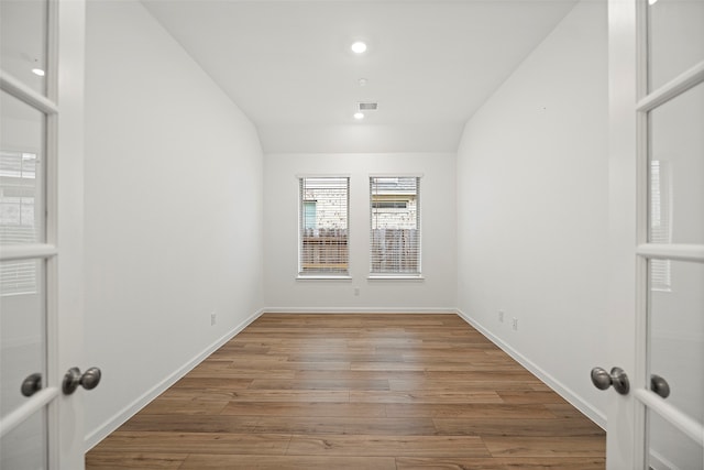 unfurnished room with vaulted ceiling and light hardwood / wood-style floors