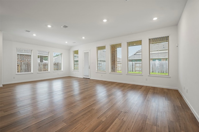 unfurnished living room featuring wood-type flooring and a healthy amount of sunlight