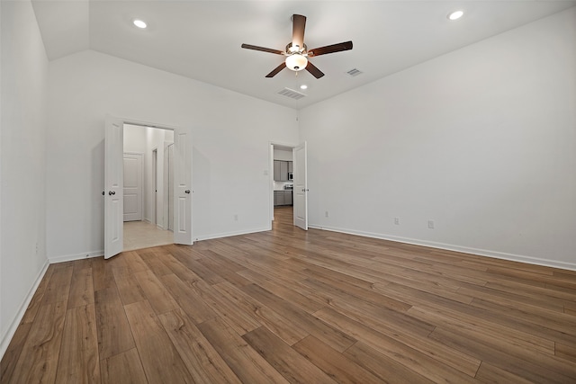 unfurnished bedroom featuring lofted ceiling, light hardwood / wood-style flooring, and ceiling fan