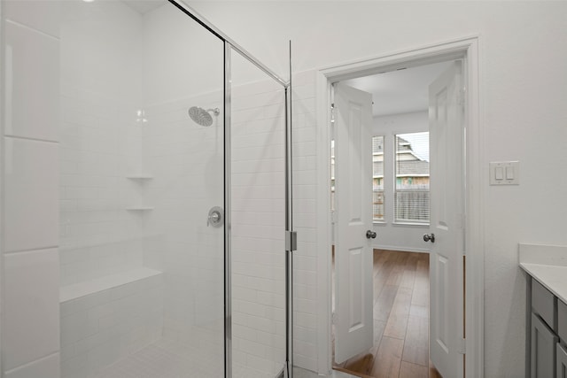 bathroom with vanity, a shower with shower door, and wood-type flooring