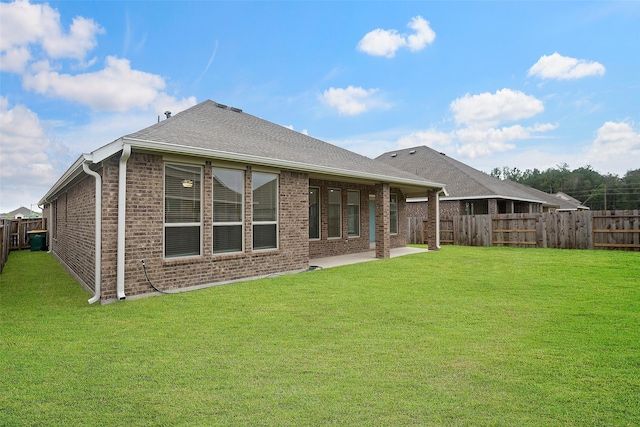 back of house with a yard and a patio