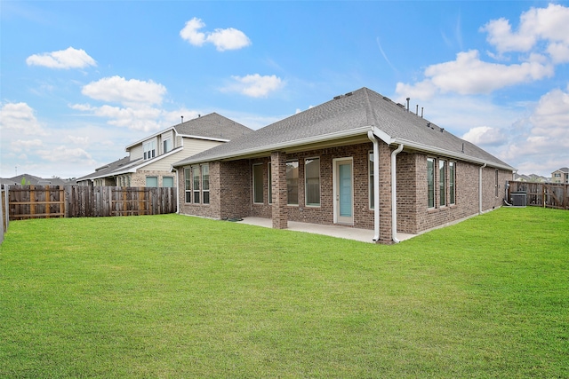 rear view of house featuring a lawn, a patio area, and central AC unit