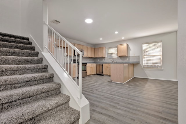 kitchen featuring appliances with stainless steel finishes, light brown cabinetry, a wealth of natural light, and kitchen peninsula