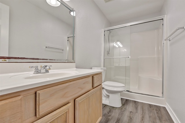 bathroom featuring an enclosed shower, hardwood / wood-style floors, toilet, and vanity