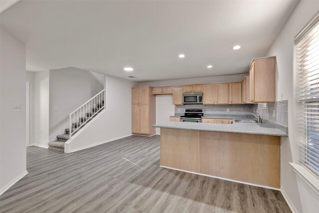 770 Hunt Rd Unit 212, Baytown, TX 77521 - kitchen featuring light wood finished floors, recessed lighting, stainless steel appliances, light brown cabinets, and baseboards