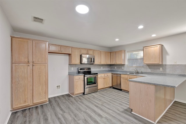 kitchen featuring light brown cabinetry, appliances with stainless steel finishes, kitchen peninsula, and light hardwood / wood-style flooring