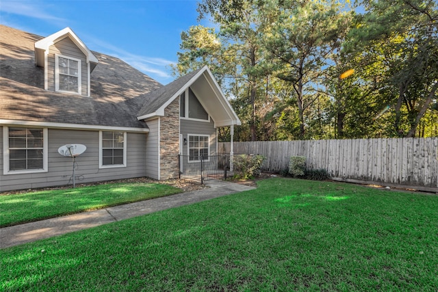 770 Hunt Rd Unit 212, Baytown, TX 77521 - exterior space featuring fence private yard, roof with shingles, a front yard, and stone siding