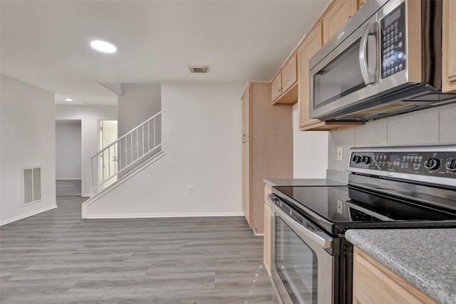 770 Hunt Rd Unit 212, Baytown, TX 77521 - kitchen featuring light brown cabinetry, visible vents, stainless steel appliances, and light wood-style floors