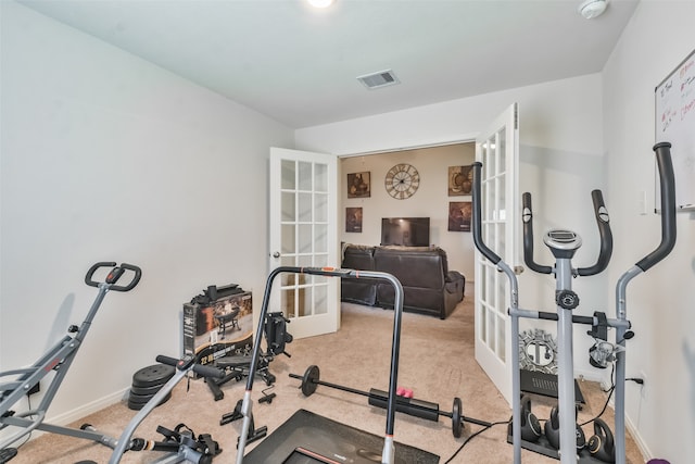 workout room featuring light carpet