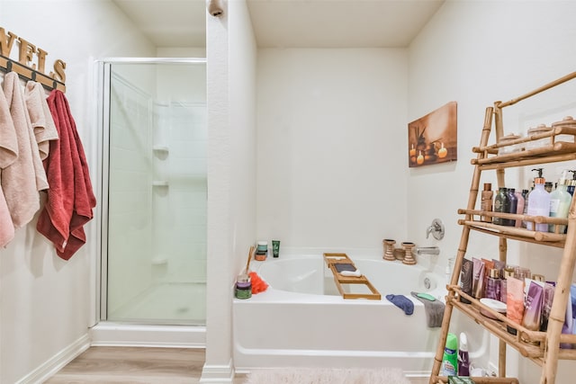 bathroom featuring independent shower and bath and hardwood / wood-style flooring