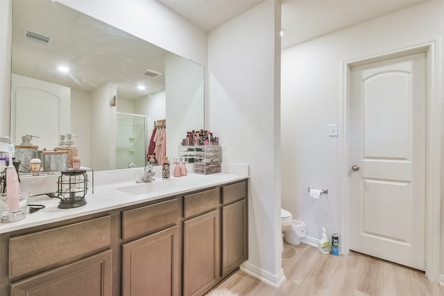 bathroom with walk in shower, toilet, hardwood / wood-style flooring, and vanity