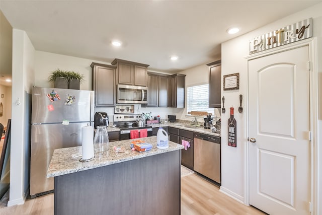 kitchen featuring a center island, stainless steel appliances, light hardwood / wood-style floors, sink, and dark brown cabinetry