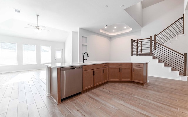 kitchen with sink, dishwasher, ceiling fan, light hardwood / wood-style floors, and an island with sink